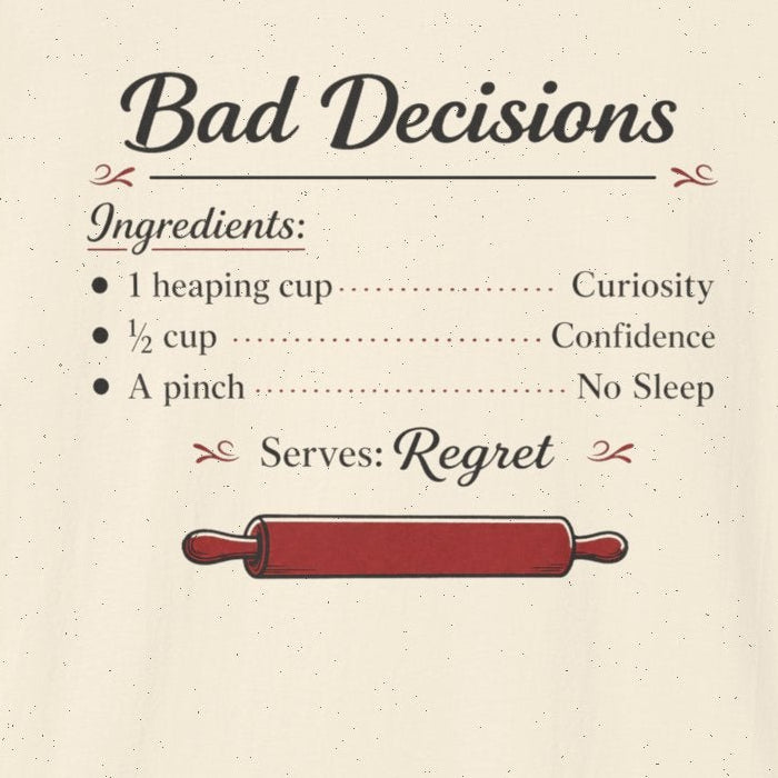 An off-white short-sleeve t-shirt with a graphic print on the front. The print is styled like a recipe titled 'Bad Decisions' with ingredients listed as 'Curiosity', 'Confidence', and 'No Sleep', and a red rolling pin graphic below.