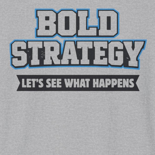 A light gray heather crewneck t-shirt featuring a graphic print on the chest that reads 'BOLD STRATEGY' in blue and white block letters, with the phrase 'LET'S SEE WHAT HAPPENS' below it in white text on a black bar.
