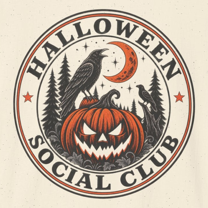 An off-white short-sleeve t-shirt with a circular graphic on the chest reading 'HALLOWEEN SOCIAL CLUB' around a jack-o'-lantern, raven, and crescent moon design, shown on a plain white background.