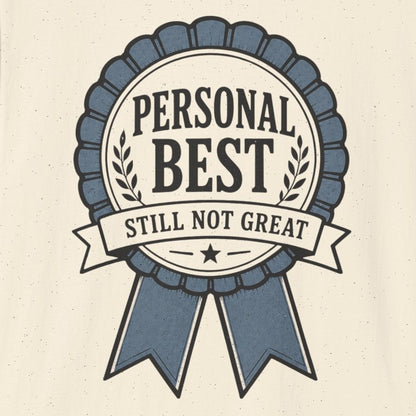 An off-white short-sleeve crewneck t-shirt featuring a blue and gray graphic badge on the front with the text 'PERSONAL BEST STILL NOT GREAT'.