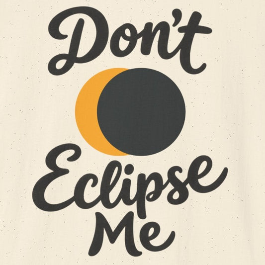 An off-white short-sleeve t-shirt with a graphic print that reads 'Don't Eclipse Me' in black script, featuring a crescent moon and a dark eclipse circle in the center. 