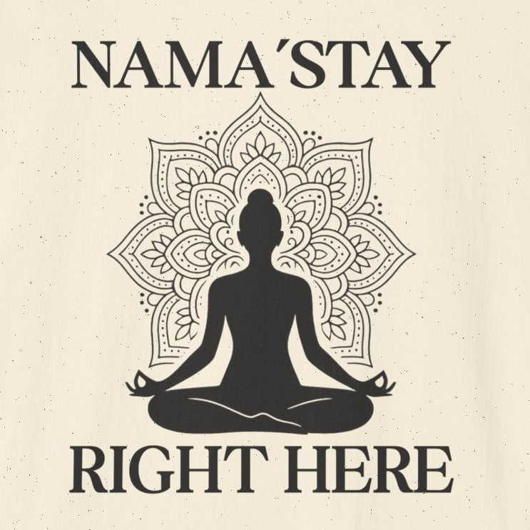 Beige t-shirt with a black silhouette of a person in meditation and text 'NAMA'STAY RIGHT HERE' 