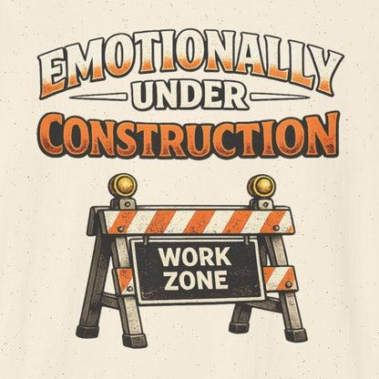 Beige t-shirt with 'Emotionally Under Construction' graphic and construction zone sign on a white background